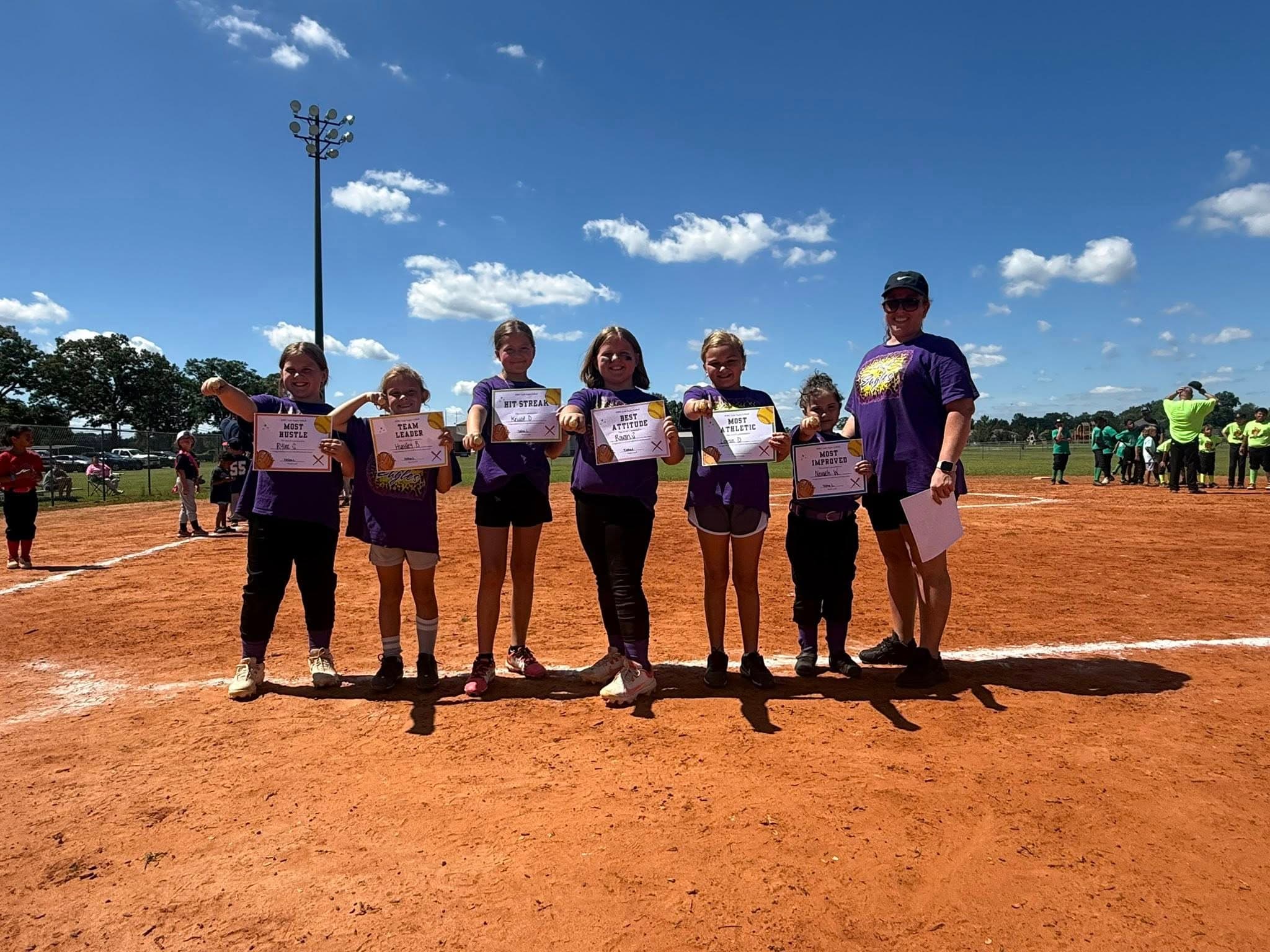 Image of girls softball team with thier trophies.